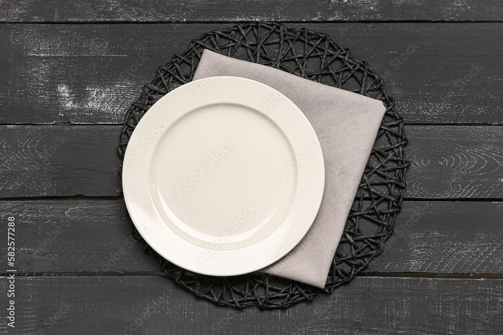 Stylish table setting with wicker mat on dark wooden background