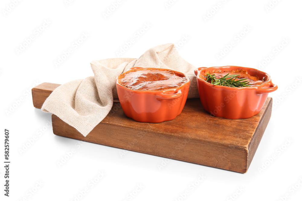 Board with delicious meat pies in baking forms isolated on white background