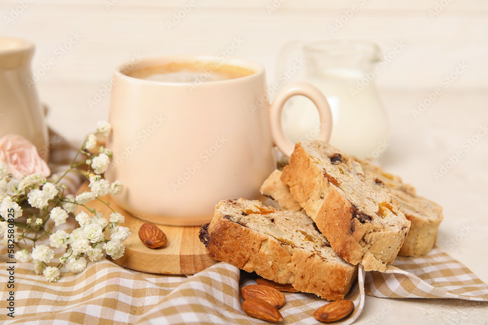 Delicious biscotti cookies, gypsophila flowers and cup of coffee on napkin