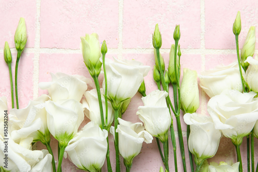 White eustoma flowers on color tile background, closeup