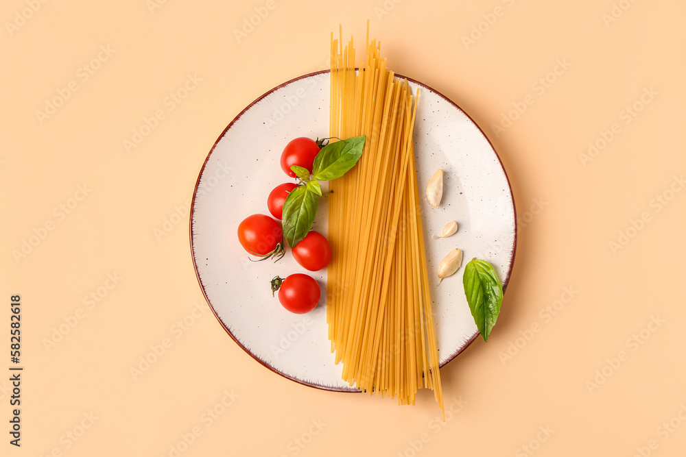 Plate with raw pasta and ingredients for pesto sauce on light background