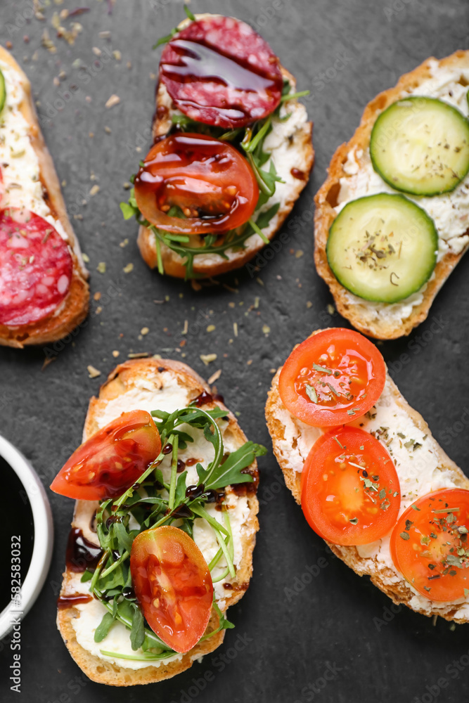 Slate board with tasty sandwiches, closeup