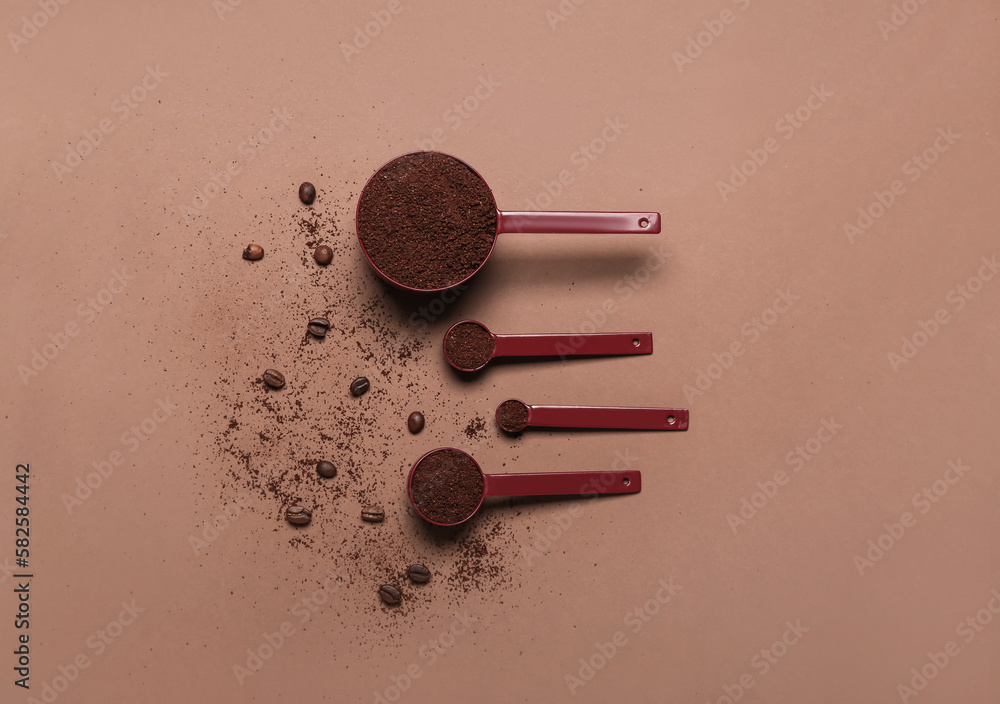 Spoons of coffee powder and beans on brown background