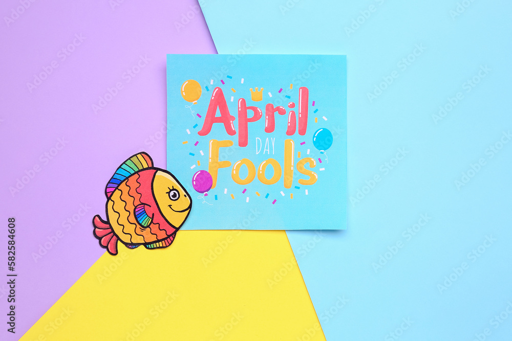 Paper with text APRIL FOOLS DAY and fish on color background