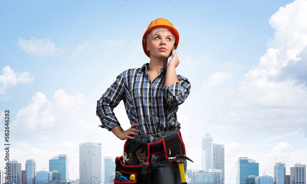 Attractive woman in workwear and hardhat