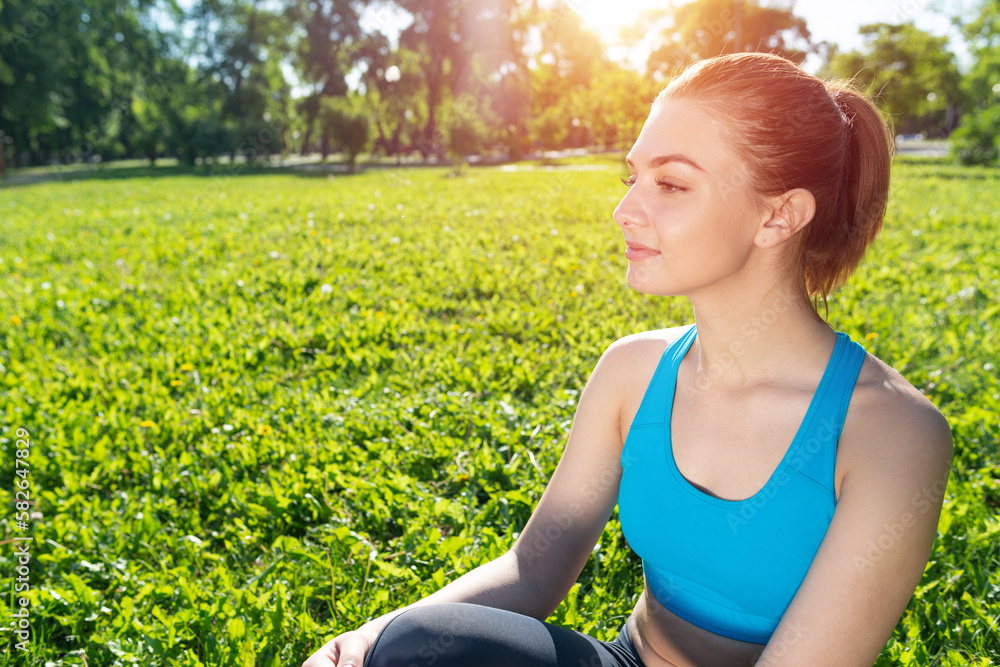 Beautiful smiling girl in sportswear relax in park