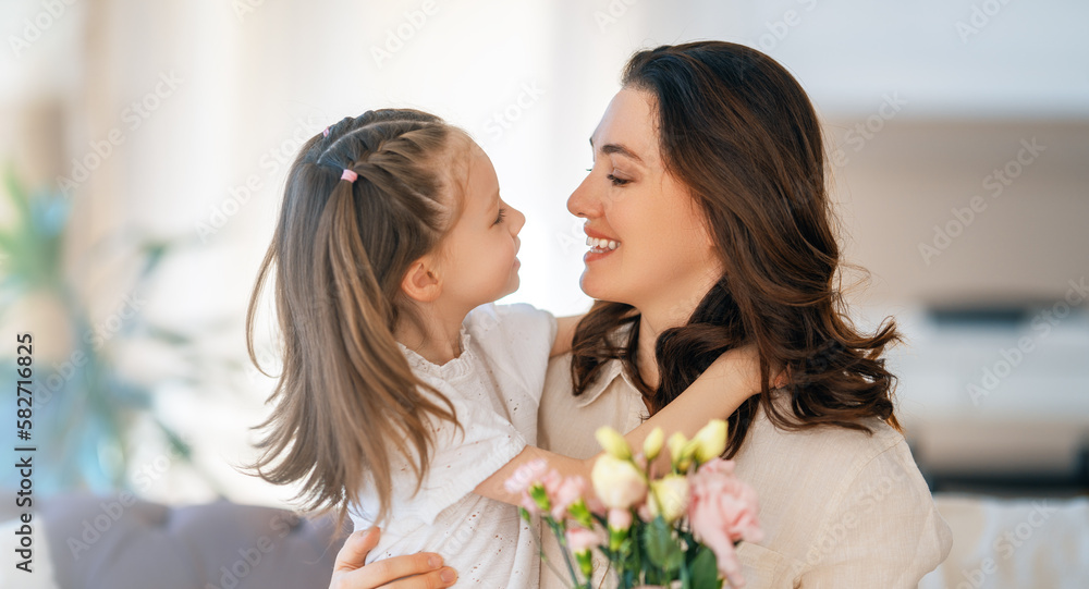 Daughter giving mother bouquet of flowers.