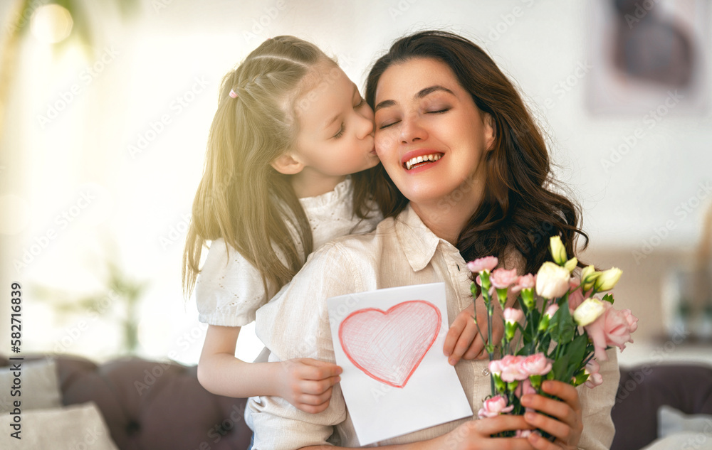 Daughter giving mother bouquet of flowers.