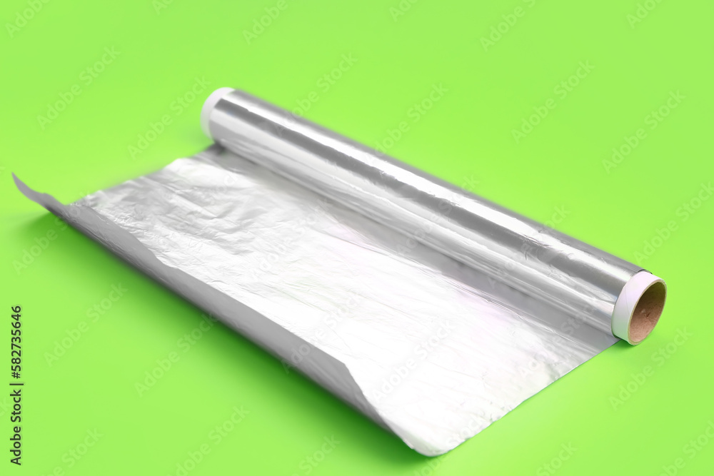 Roll of aluminium foil on green background