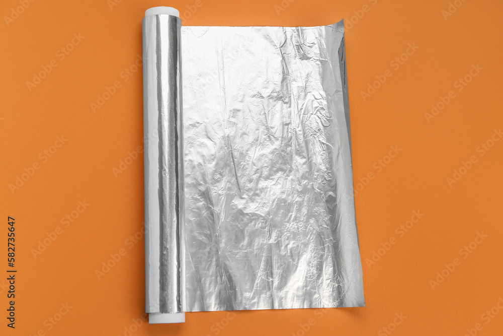 Aluminium foil roll on orange background