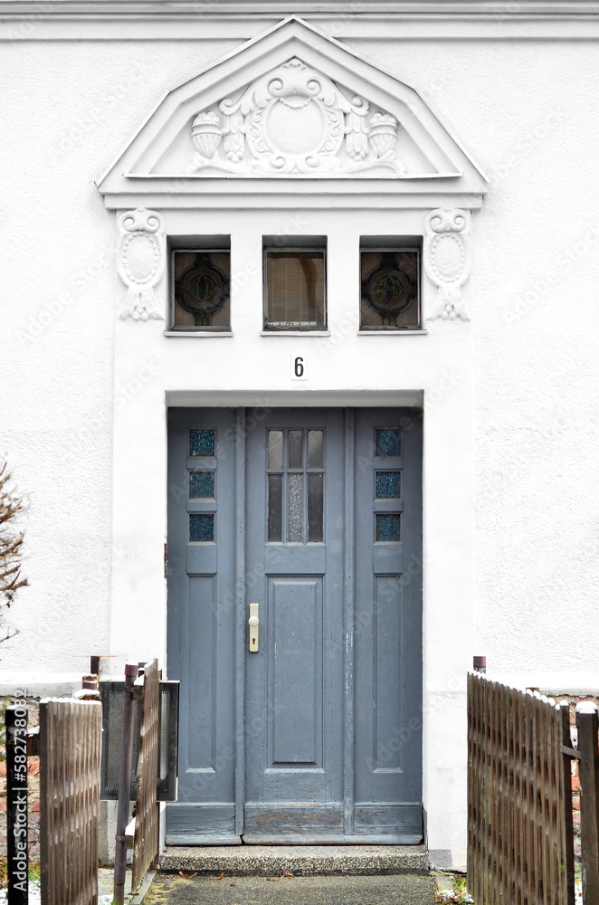 View of white building with wooden door