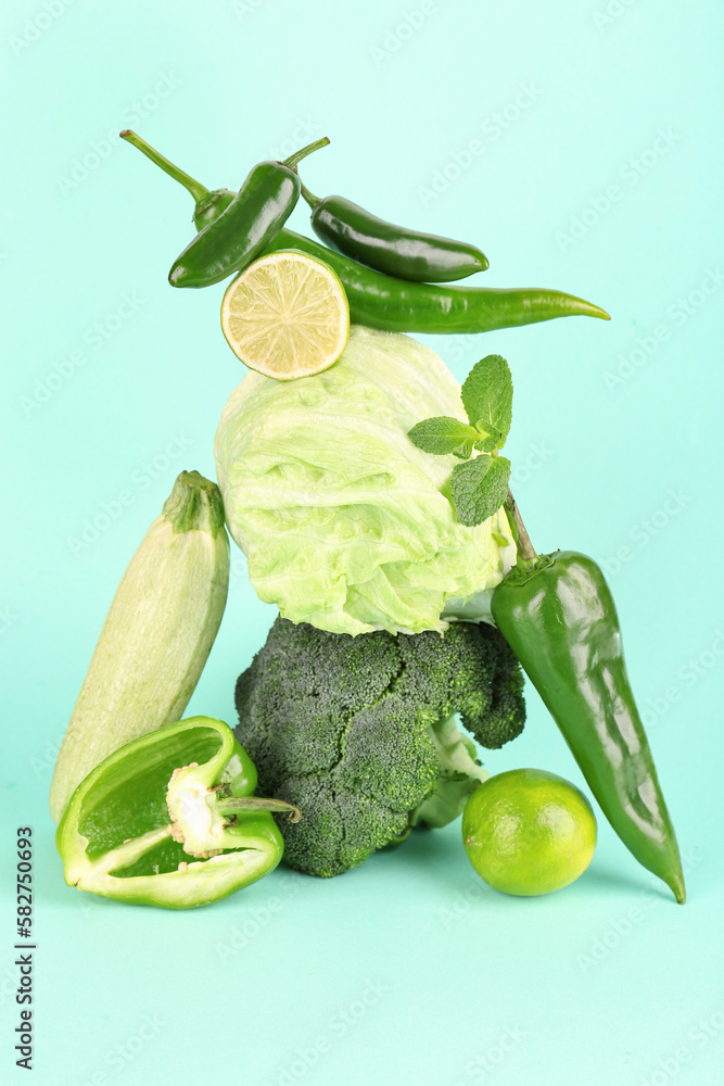 Composition with different fresh green vegetables on color background