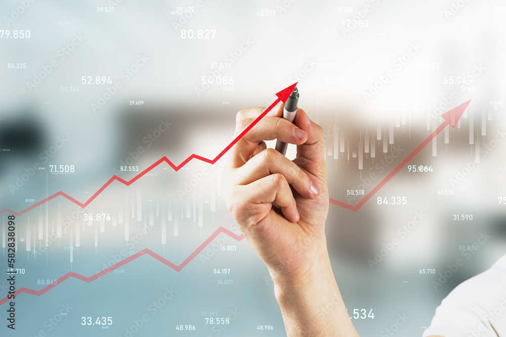 Close up of hand drawing growing red business chart arrow on blurry office interior background. Fina