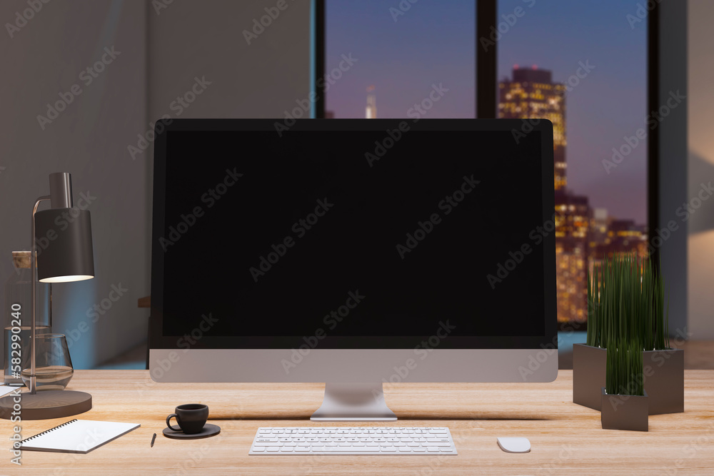 Close up of designer office desk top with empty black computer monitor, window with night city view,