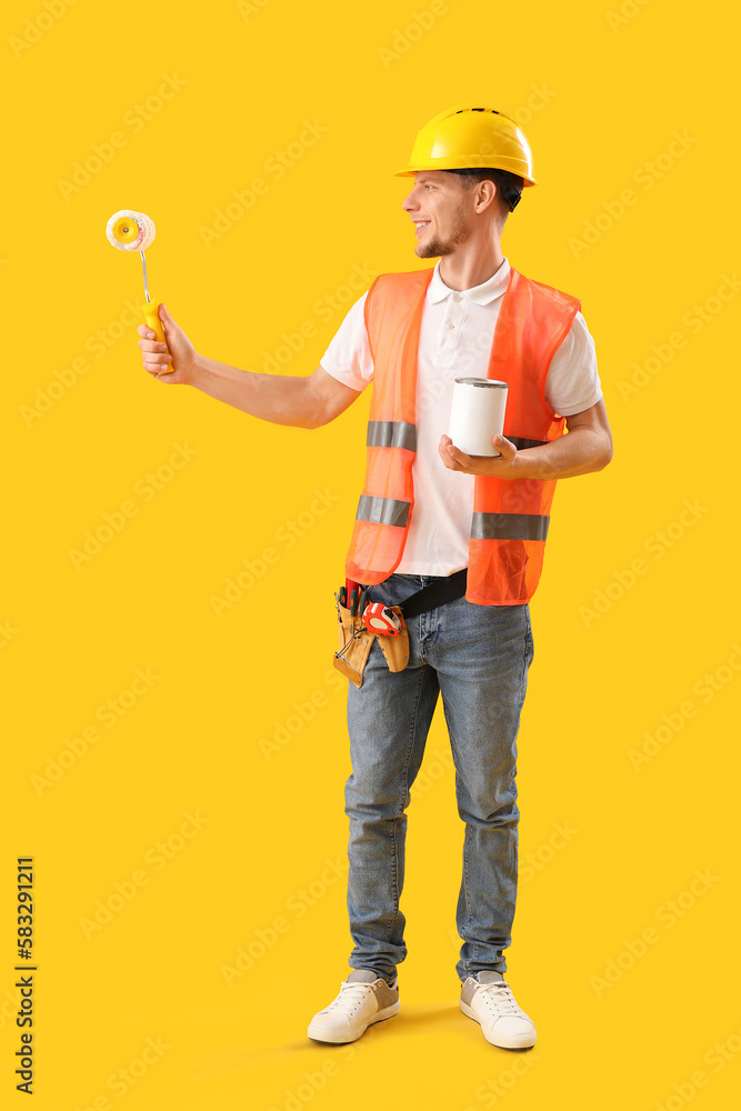 Male decorator on yellow background