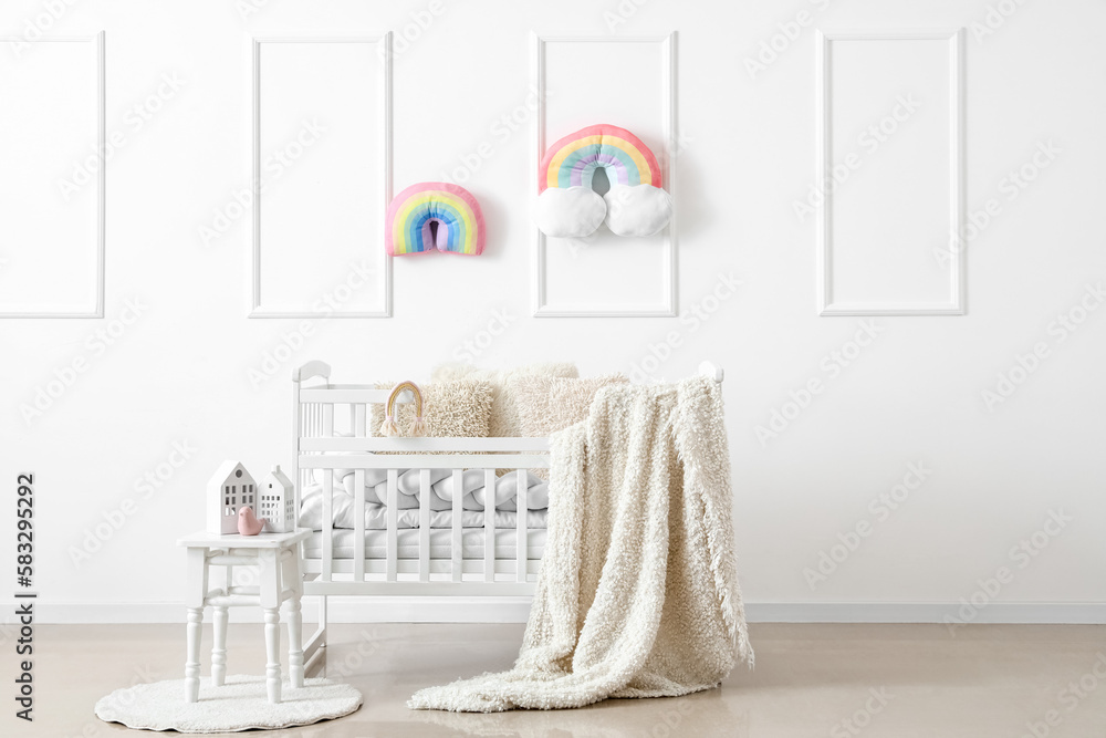 Interior of light childrens bedroom with baby crib and table