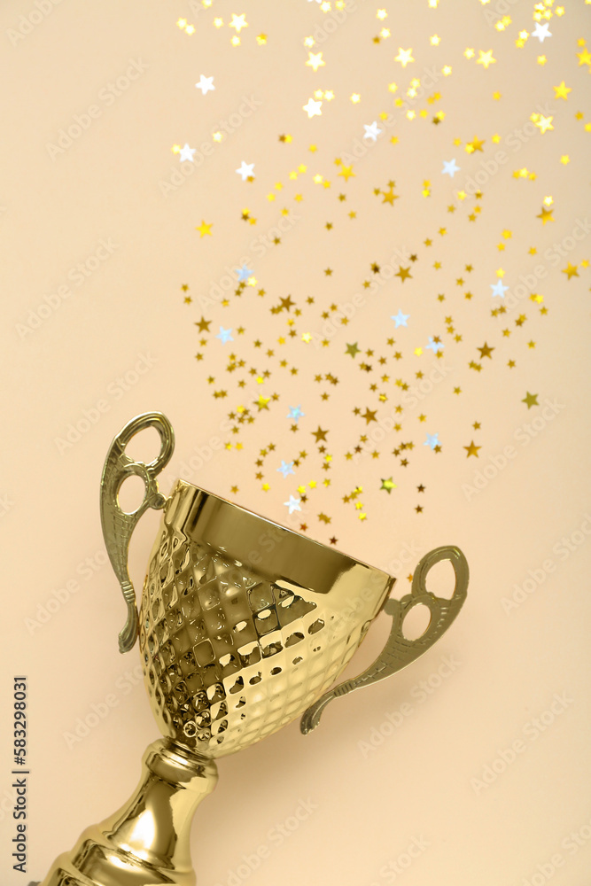 Gold cup with stars on beige background