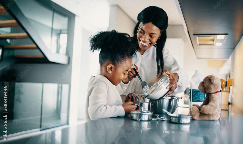 Woman teaching her daughter how to bake a cake at home