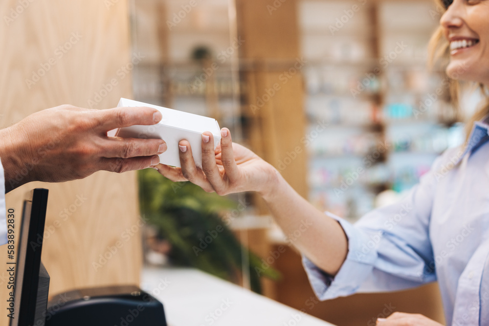 Pharmacist handing a patient a box of pills