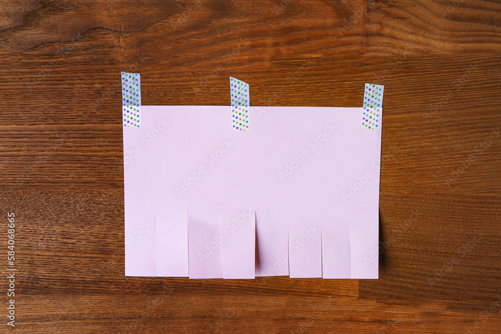 Blank paper tear-off ad on wooden background