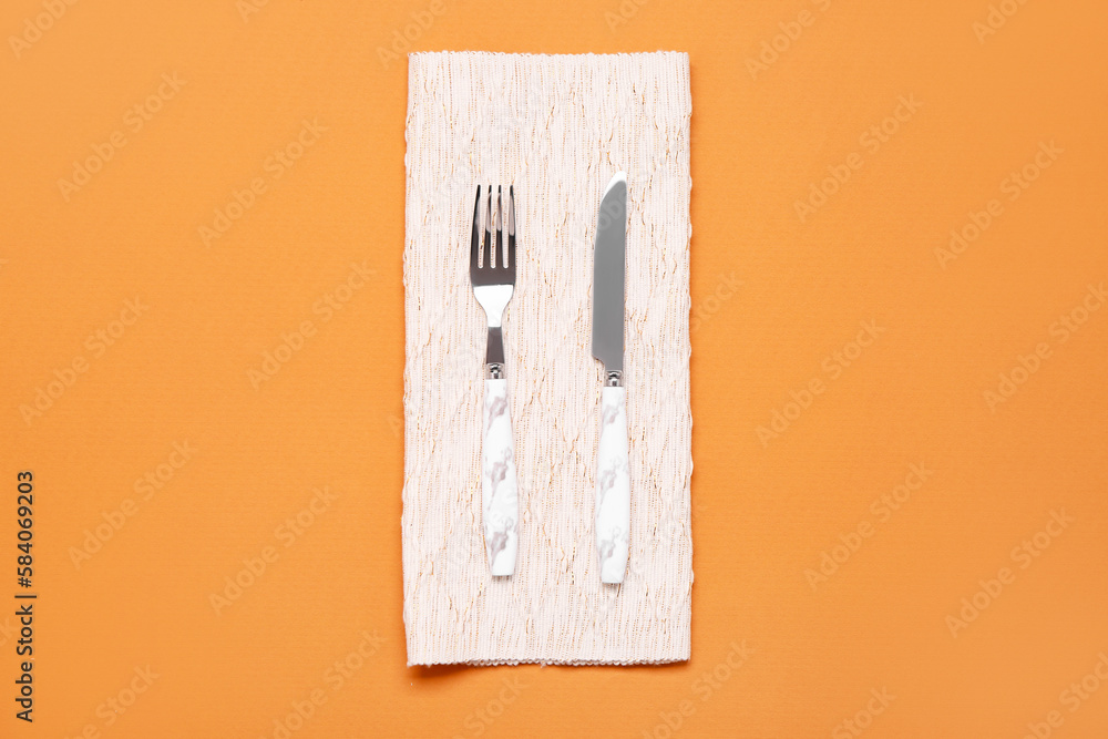 Napkin with cutlery on color background