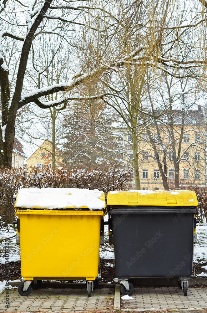 View of garbage containers in city on winter day