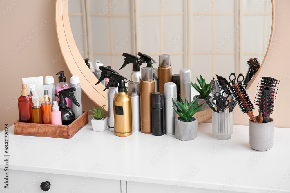 Hair sprays with accessories on table in beauty salon