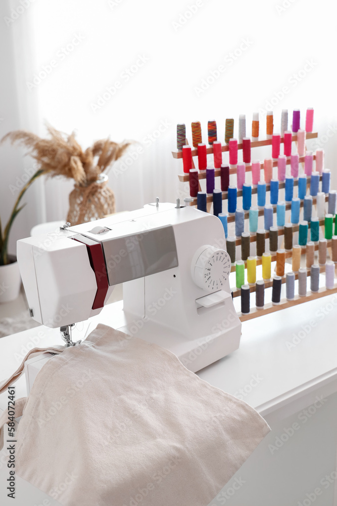 Sewing machine with cloth on table in atelier, closeup