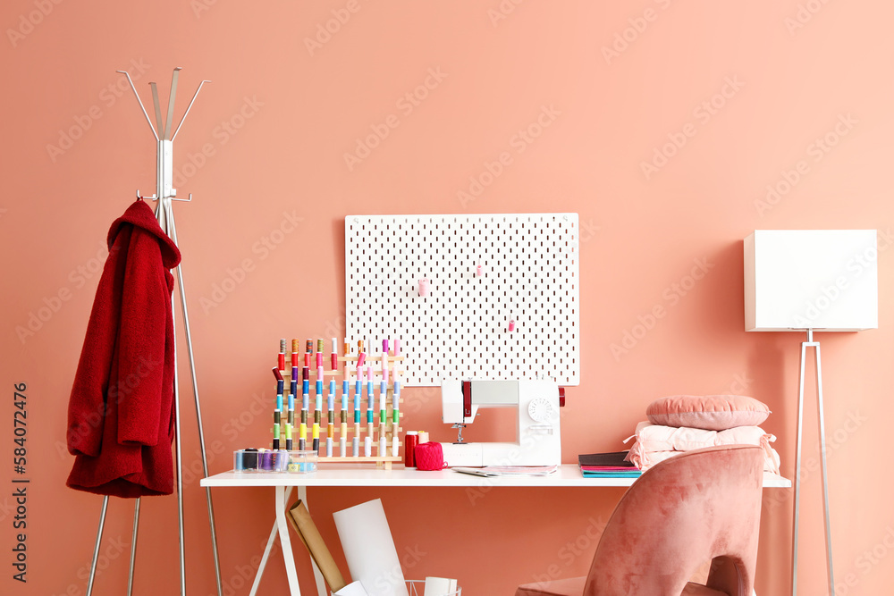 Interior of atelier with tailors workplace, thread spools and pegboard