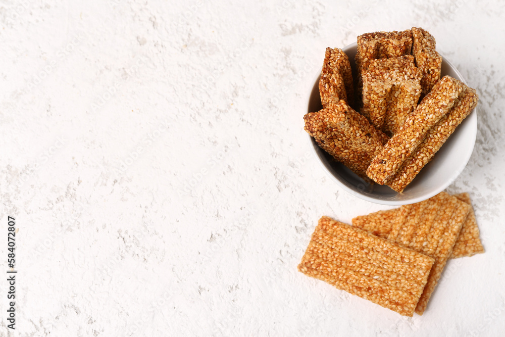 Bowl of sweet sesame kozinaki on light background