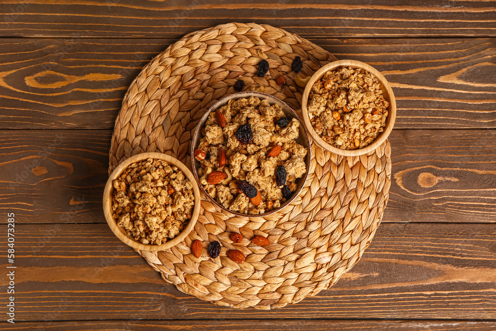 Bowls of tasty granola on wooden background