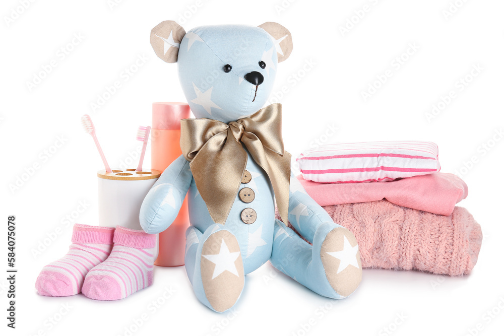 Toy bear with baby clothes and accessories on white background