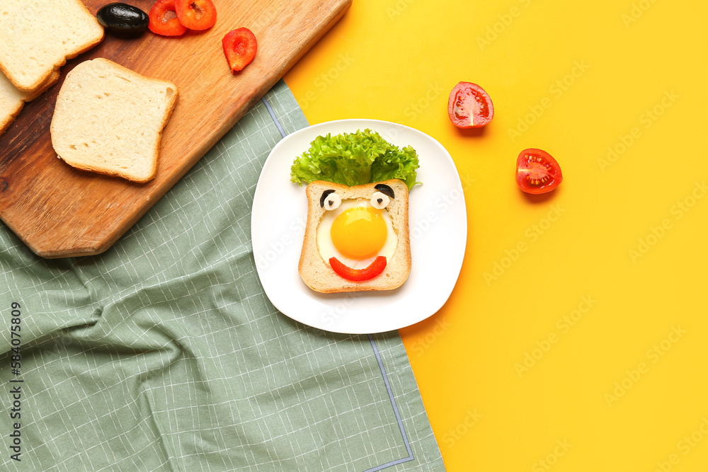 Plate with funny toast and tomatoes on yellow background