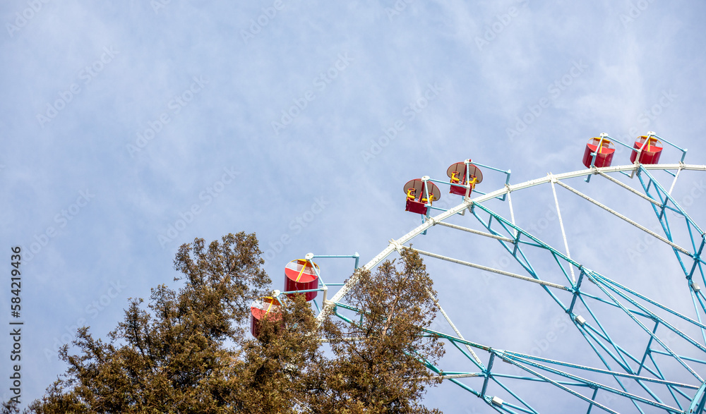 Ferris wheel, booths against the blue sky.