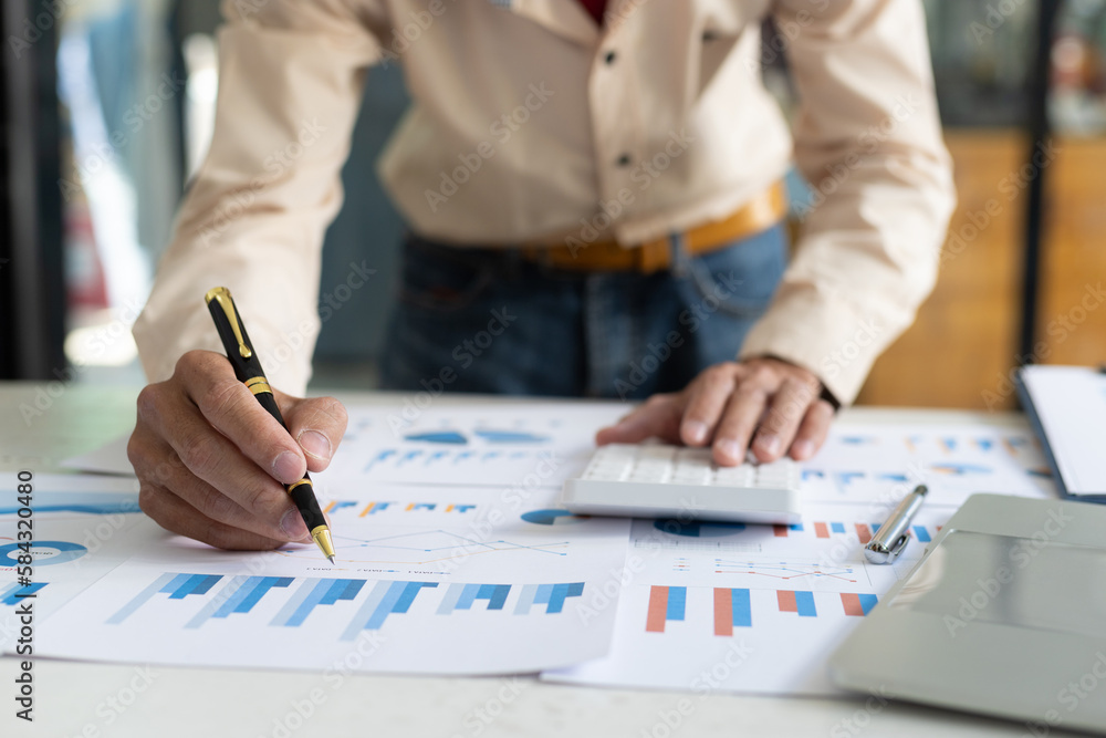 Businessman pointing at financial chart document and statistical market growth analysis. Accounting 