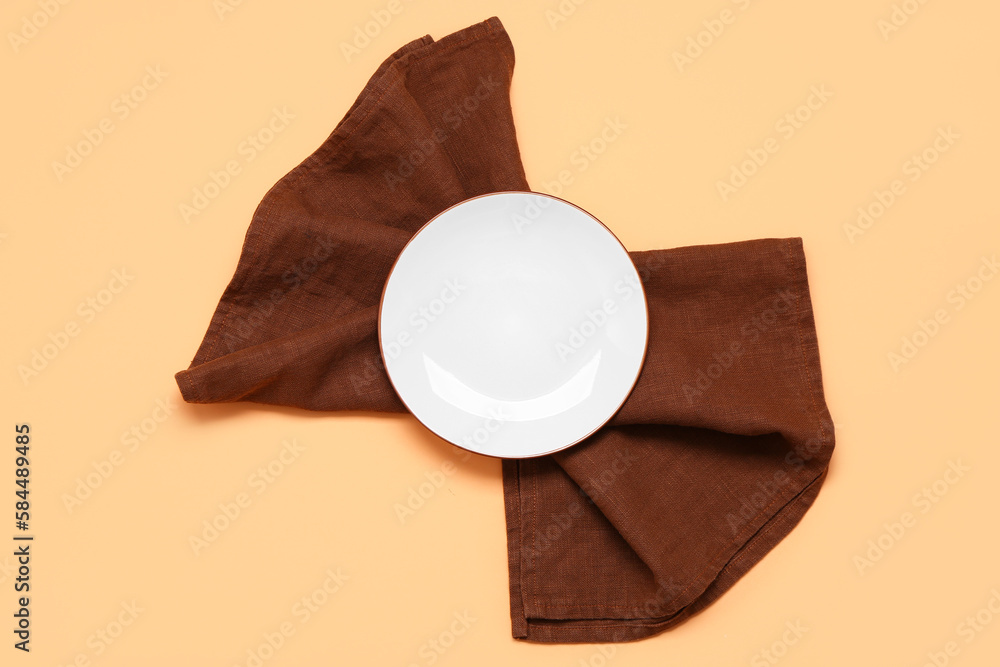 Empty plate and clean napkin on color background