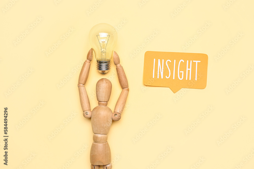 Wooden mannequin with light bulb and word INSIGHT on beige background