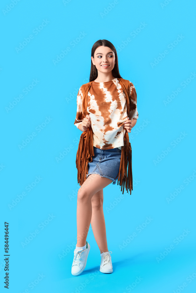 Stylish young woman in tie-dye t-shirt on light blue background