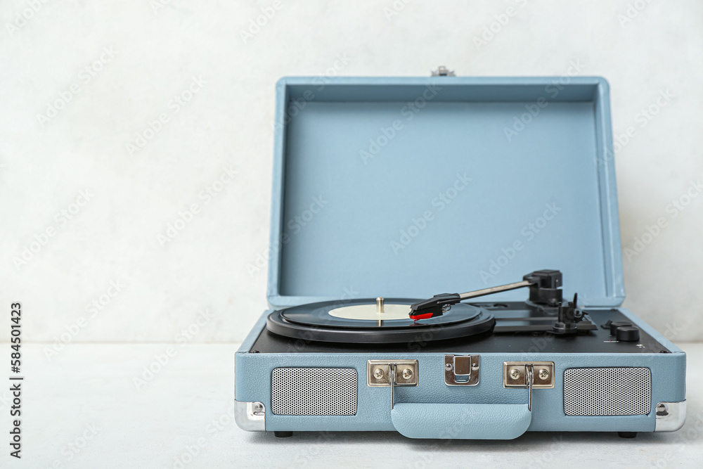 Record player with vinyl disk on white table