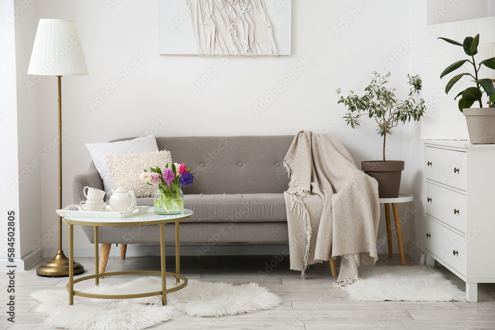 Interior of modern living room with cozy sofa, coffee table and lamp