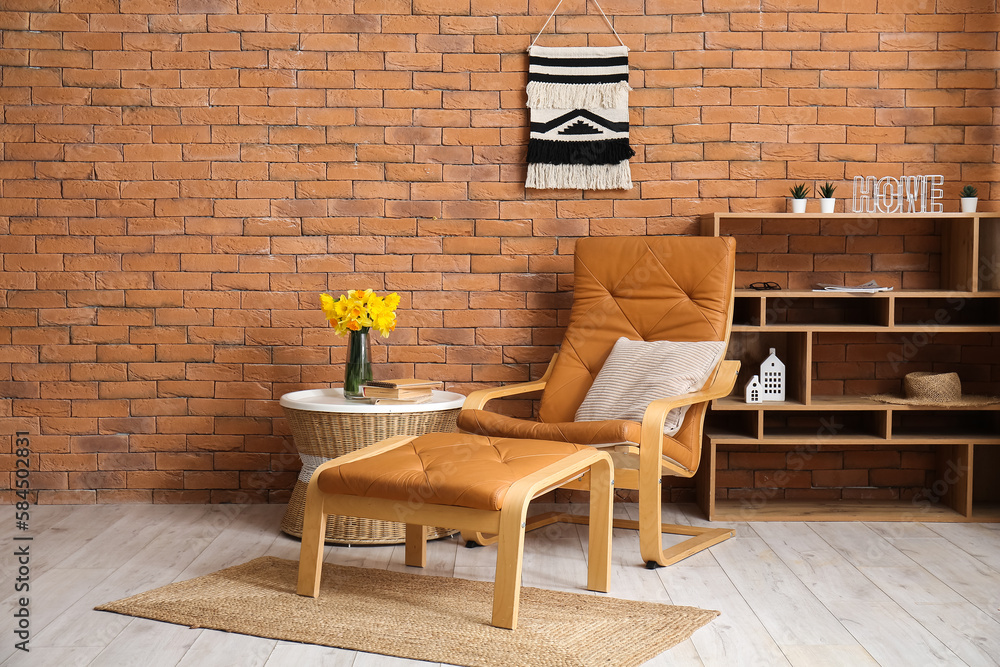 Interior of living room with cozy armchair, footstool and coffee table