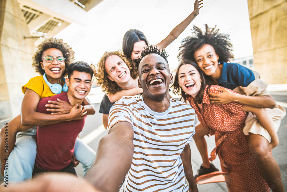 Happy multicultural friends taking selfie portrait walking on city street - University students havi