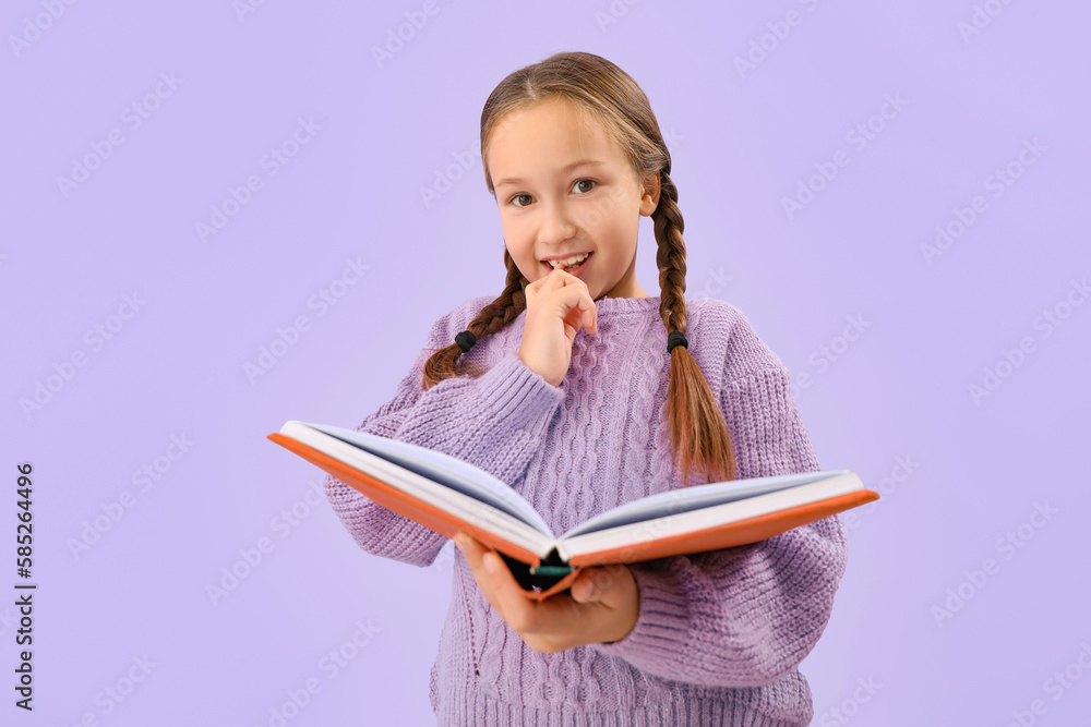 Little girl with book biting nails on lilac background