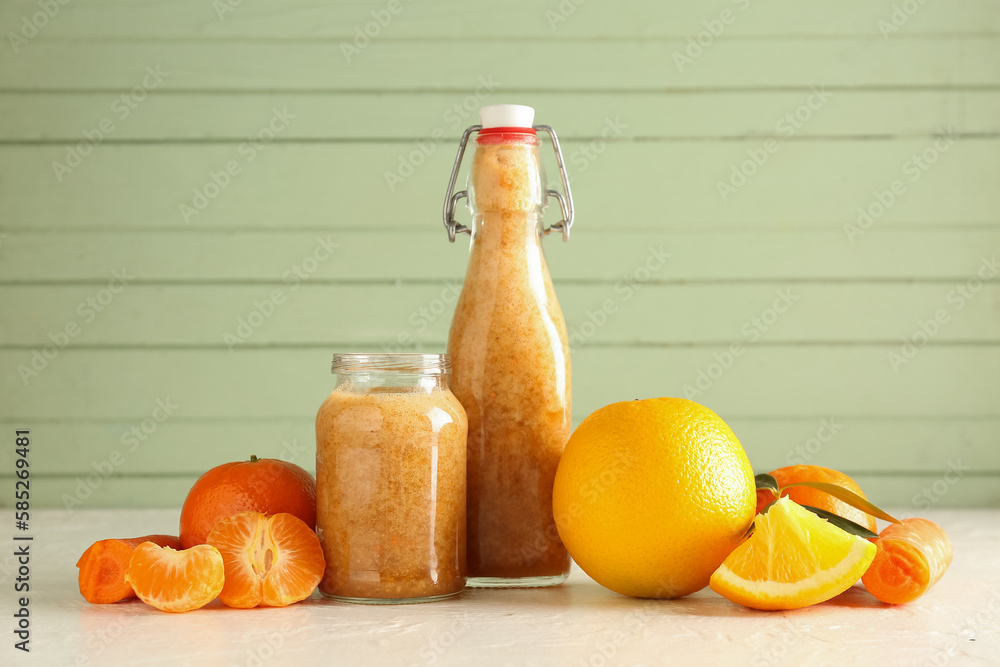 Bottle and jar of healthy smoothie with ingredients on table