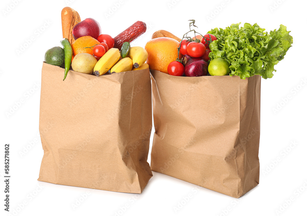 Paper bags with vegetables and fruits on white background