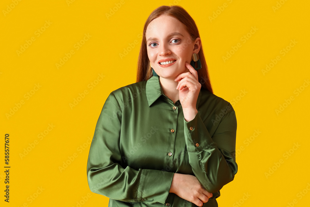 Beautiful redhead woman on yellow background