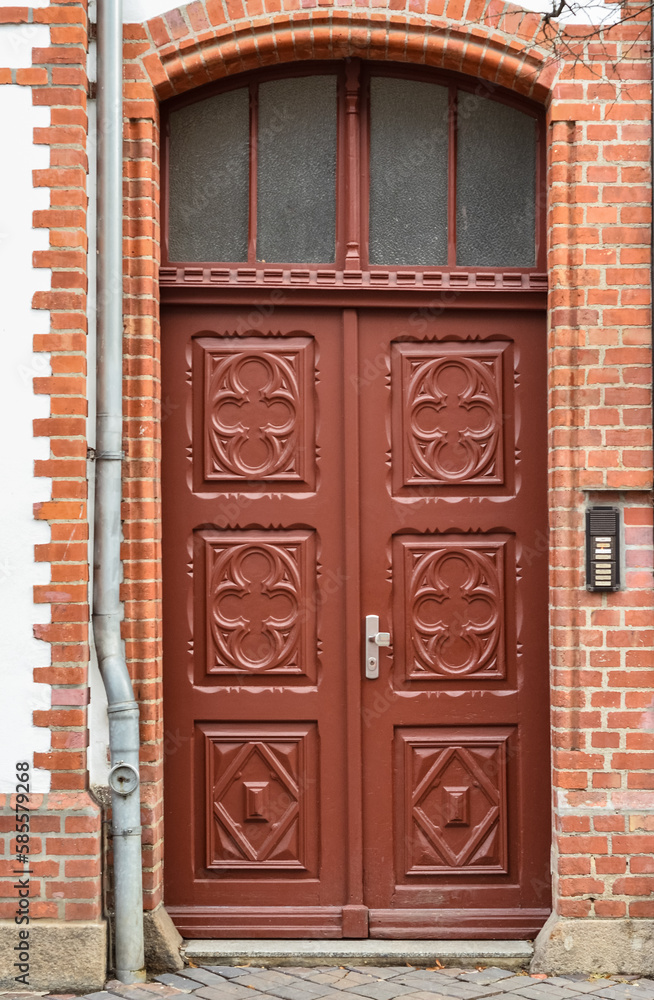 View of brick building with ornate wooden door