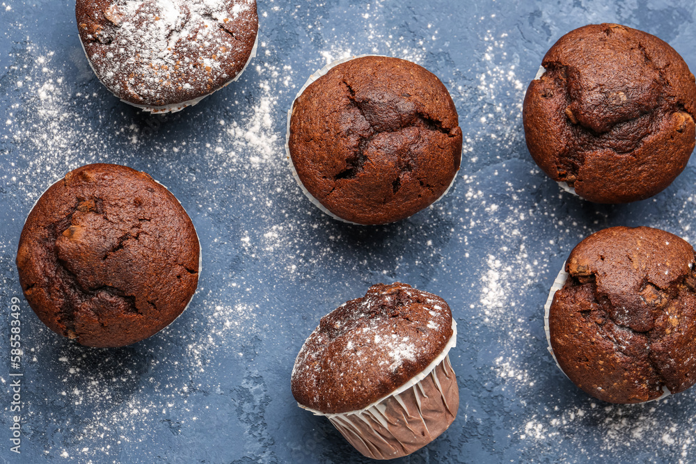 Tasty chocolate cupcakes on blue background