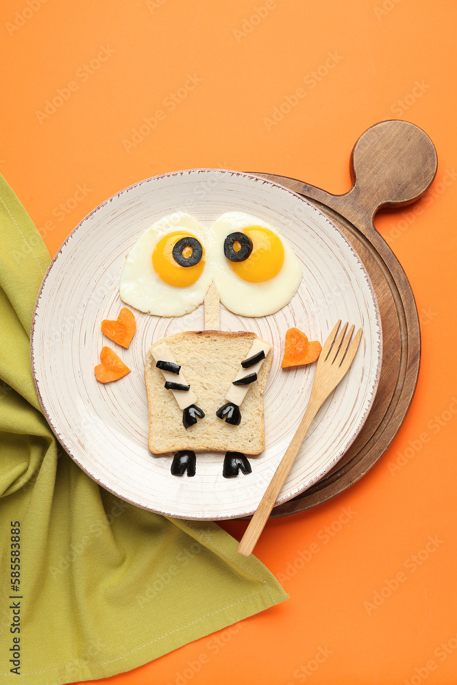 Plate with funny childrens breakfast on orange background