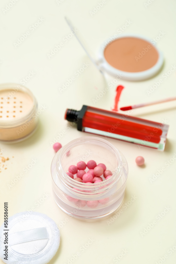 Lipstick with makeup powder on beige background, closeup